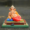 Ganpati Bappa seated on a traditional pat, 4 inch Ganesh idol